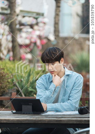 young man with laptop sitting on bench young man with laptop sitting on bench 105839790