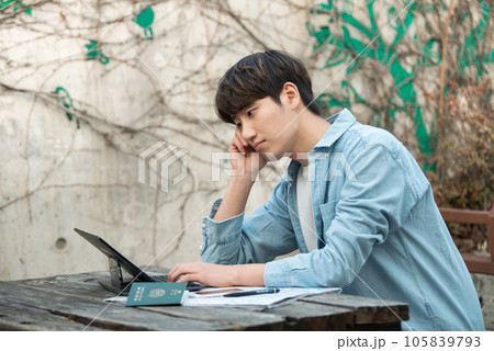 young man with laptop sitting on bench 105839793