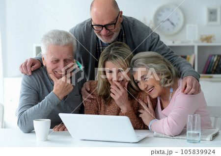 two senior couples sitting at table and using laptop two senior couples sitting at table and using laptop 105839924