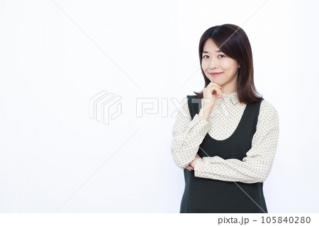 白い背景の前で笑顔で考えている30代の女性 105840280