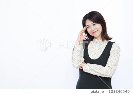 白い背景の前で笑顔で考えている30代の女性 白い背景の前で笑顔で考えている30代の女性 105840340