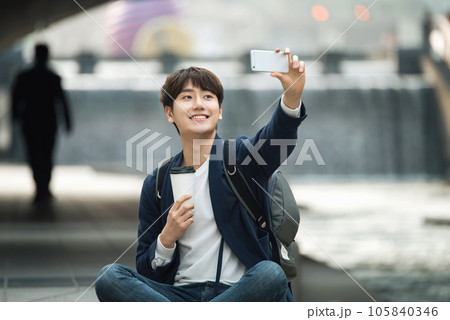 a young man relaxing over a cup of coffee by the city's river 105840346