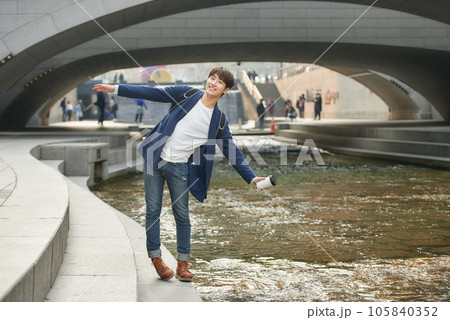 a young man relaxing over a cup of coffee by the city's river 105840352