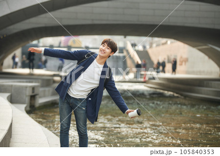 a young man relaxing over a cup of coffee by the city's river 105840353
