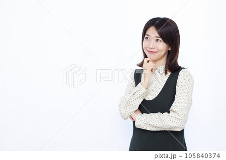 白い背景の前で笑顔で考えている30代の女性 105840374