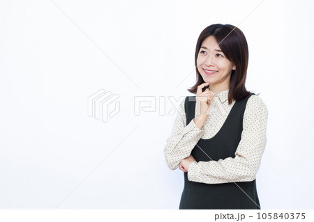 白い背景の前で笑顔で考えている30代の女性 105840375