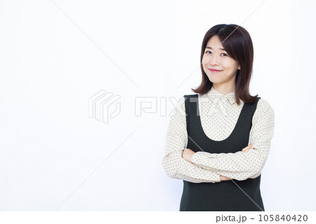 腕組みをして笑顔で考えている30代の女性 105840420