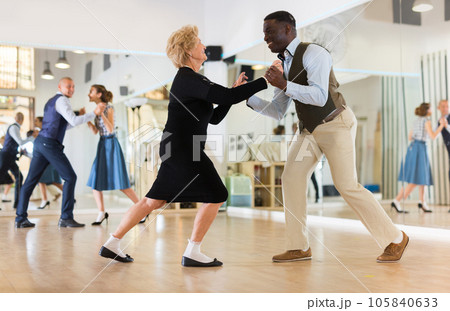 Lady learning to dance lindy hop with man in dance school Lady learning to dance lindy hop with man in dance school 105840633