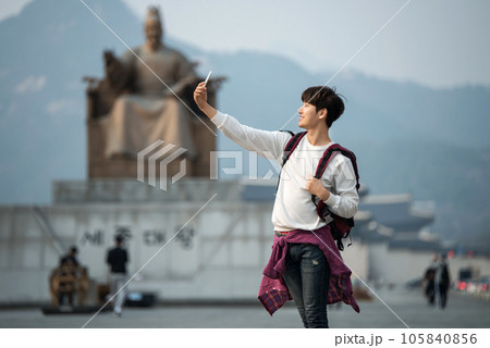 A young man taking pictures with a smartphone camera in Seoul, Korea's representative city A young man taking pictures with a smartphone camera in Seoul, Korea's representative city 105840856
