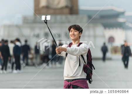 A young man taking pictures with a smartphone camera in Seoul, Korea's representative city 105840864
