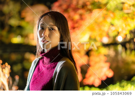 ライトアップされた紅葉を楽しむ若い女性 105843069