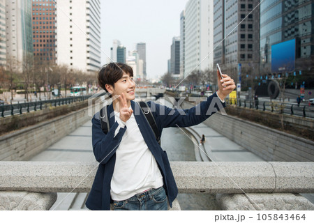 A young man traveling in Seoul, South Korea, with a backpack A young man traveling in Seoul, South Korea, with a backpack 105843464