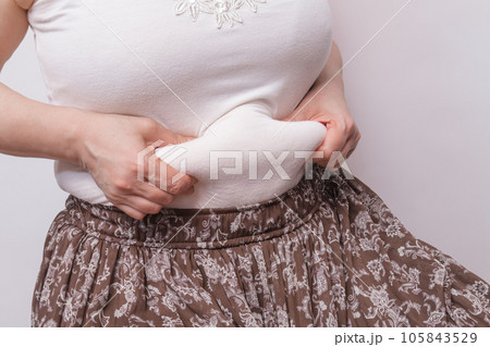 【お腹の肉を摘む主婦】 105843529