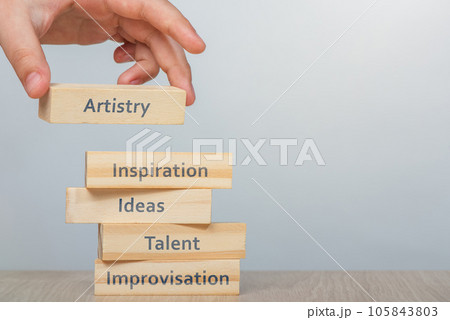 Artistry concept. Hand places the wooden rectangles next to the others, creating a wall of wooden cubes with the words Inspiration, Ideas and Improvisation that combine the word ARTISTRY. Copy space. Artistry concept. Hand places the wooden rectangles next to the others, creating a wall of wooden cubes with the words Inspiration, Ideas and Improvisation that combine the word ARTISTRY. Copy space. 105843803