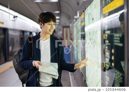 a young man holding a map at a train station 105844606