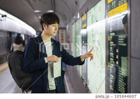 a young man holding a map at a train station a young man holding a map at a train station 105844607