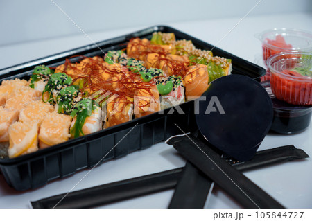 Rolls with red fish, rice, avocado, saffron. Set of rolls in a plate on a white background Rolls with red fish, rice, avocado, saffron. Set of rolls in a plate on a white background 105844727