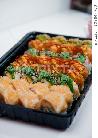 Rolls with red fish, rice, avocado, saffron. Set of rolls in a plate on a white background 105844733