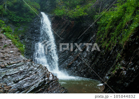 Mountain waterfall, large water flow of mountain waterfall, mountain river near the rock. Huk Waterfall, Ukrainian Carpathians 105844832