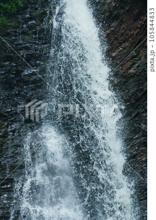 Mountain waterfall, large water flow of mountain waterfall, mountain river near the rock. Huk Waterfall, Ukrainian Carpathians 105844833
