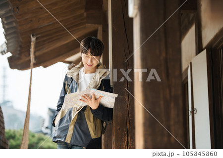 A young male college student who travels with a backpack looking at a map in Korea 105845860