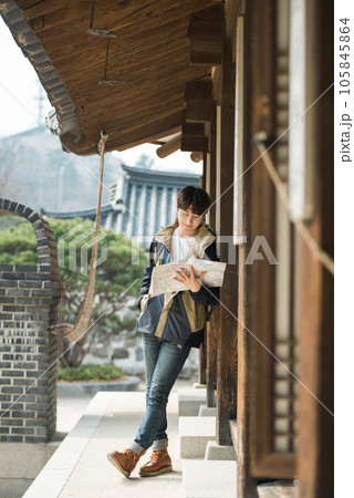 A young male college student who travels with a backpack looking at a map in Korea 105845864