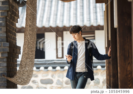 A young male college student looking at his smartphone while traveling to Korea 105845996