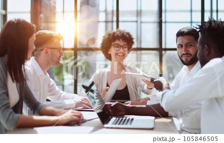 Employees working at computer together, discussing content 105846505