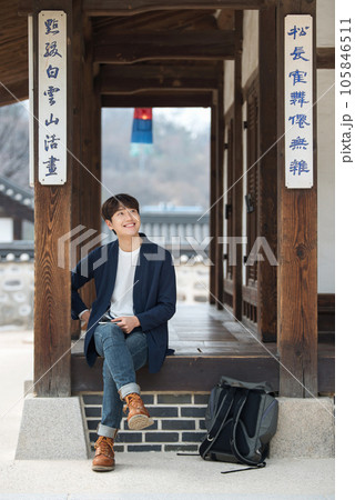 A young man sitting on the stairs looking at his smartphone A young man sitting on the stairs looking at his smartphone 105846511