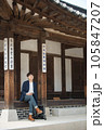 A young man sitting on the stairs looking at his smartphone 105847207
