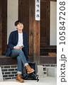 A young man sitting on the stairs looking at his smartphone 105847208
