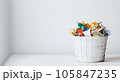 Plastic white basket full of crumpled colourful paper on the white background 105847235