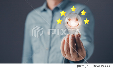 person hand holding power lightbulb and select on the five star to give satisfaction in service.rating very impressed.Customer service and Satisfaction concept. person hand holding power lightbulb and select on the five star to give satisfaction in service.rating very impressed.Customer service and Satisfaction concept. 105849333