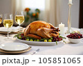 A juicy roast turkey takes center stage on a crisp white dining table in a modern, well-lit dining room 105851065