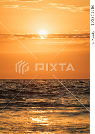 Ocean waves on sunset with setting sun background 105851366