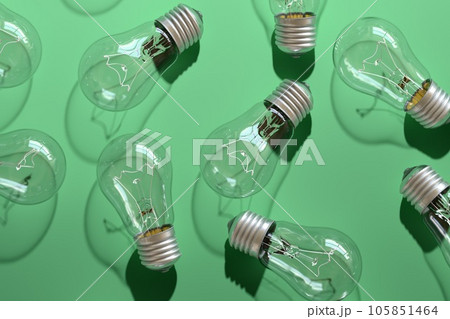 Close-up of an incandescent lamp on green background. Close-up of an incandescent lamp on green background. 105851464