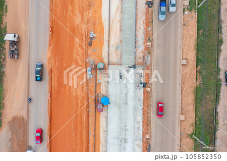 Aerial view of construction tractor car, bulldozer, or backhoe digging road or street in traffic transportation and agriculture concept. Engine working in urban city town. Aerial view of construction tractor car, bulldozer, or backhoe digging road or street in traffic transportation and agriculture concept. Engine working in urban city town. 105852350