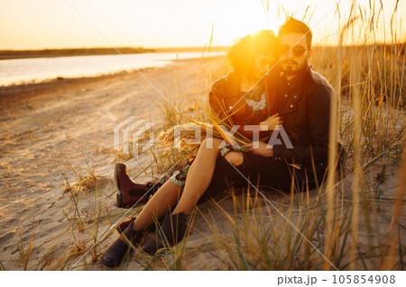 Enjoying time together. Stylish and loving couple enjoying each other by the sea. 105854908