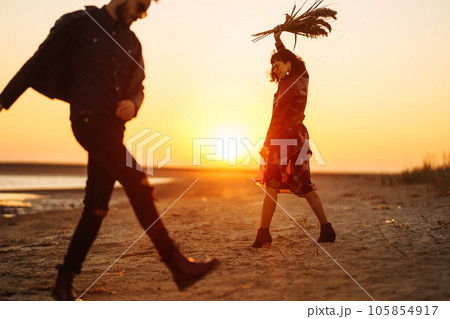 Enjoying time together. Stylish and loving couple enjoying each other by the sea. 105854917