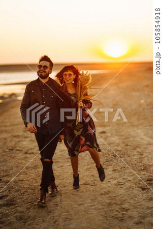 Enjoying time together. Stylish and loving couple enjoying each other by the sea. 105854918