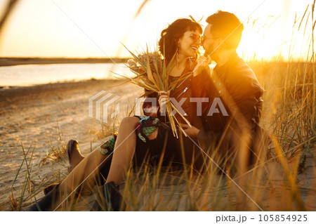 Enjoying time together. Stylish and loving couple enjoying each other by the sea. 105854925