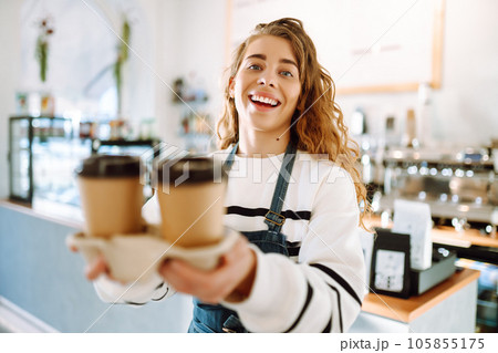 ?offee to go. Young barista girl smiling happy holding take away coffee at the cafe shop. ?offee to go. Young barista girl smiling happy holding take away coffee at the cafe shop. 105855175