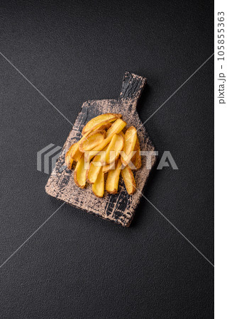 Delicious crispy potato deeps with salt and spices on a textured concrete background 105855363