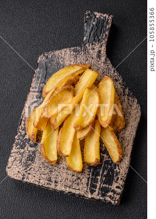 Delicious crispy potato deeps with salt and spices on a textured concrete background 105855366
