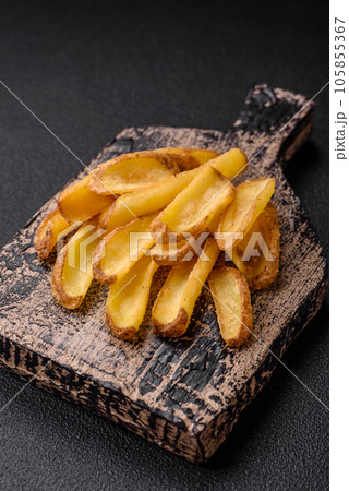 Delicious crispy potato deeps with salt and spices on a textured concrete background Delicious crispy potato deeps with salt and spices on a textured concrete background 105855367