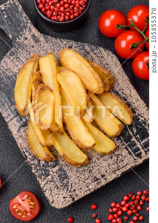 Delicious crispy potato deeps with salt and spices on a textured concrete background Delicious crispy potato deeps with salt and spices on a textured concrete background 105855370