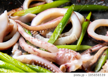 いか(ボイルイカ)とにんにくの芽をフライパンで炒める調理シーン。 いか(ボイルイカ)とにんにくの芽をフライパンで炒める調理シーン。 105856539