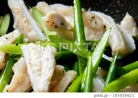 鶏軟骨(やげん軟骨)とにんにくの芽をフライパンで炒める調理シーンのアップ。 105856621