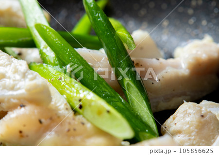 鶏軟骨(やげん軟骨)とにんにくの芽をフライパンで炒める調理シーンのアップ。 105856625