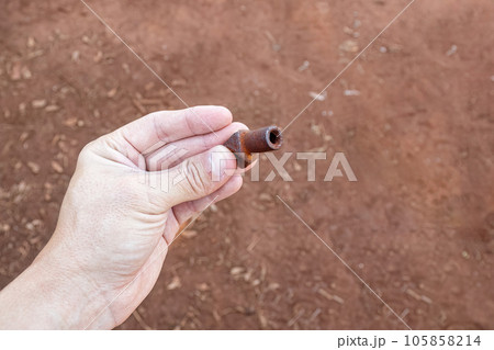 hand holding small piece of rusty metal hand holding small piece of rusty metal 105858214